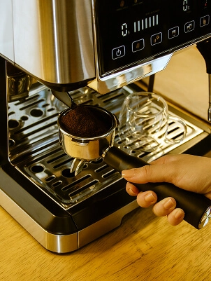 Imagem de pessoa colocando café moído na Cafeteira Due Nero